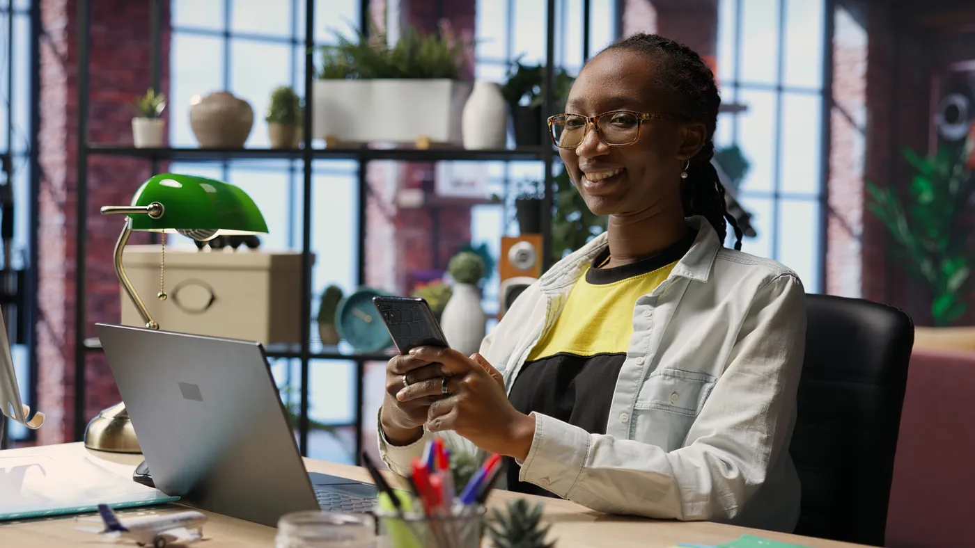 A business owner working with 390 on her laptop and phone